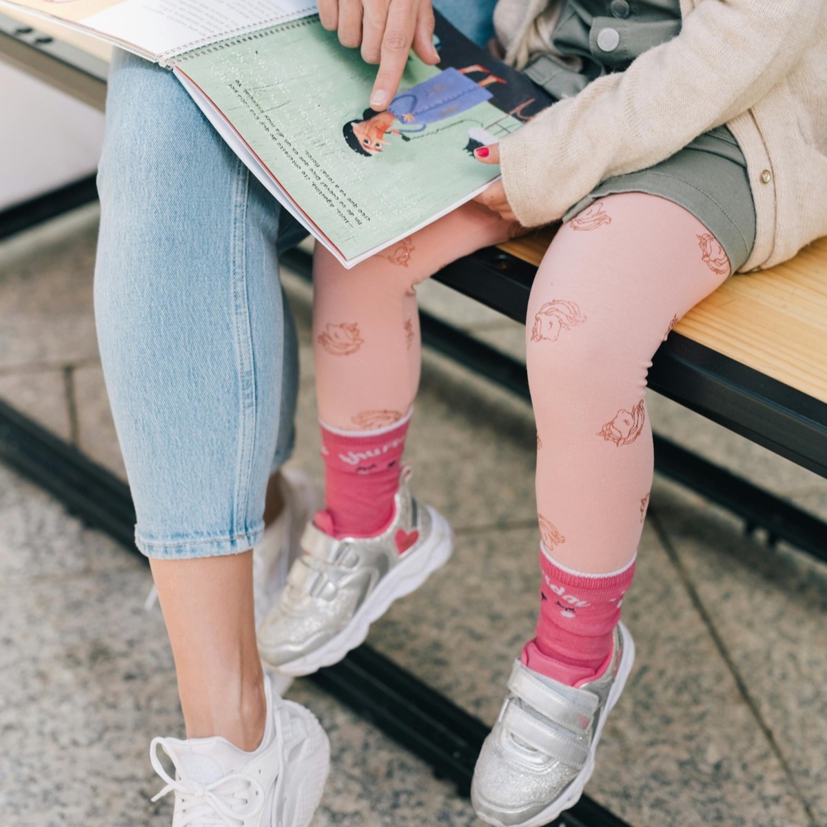 Oppas leest samen met een kind een boek