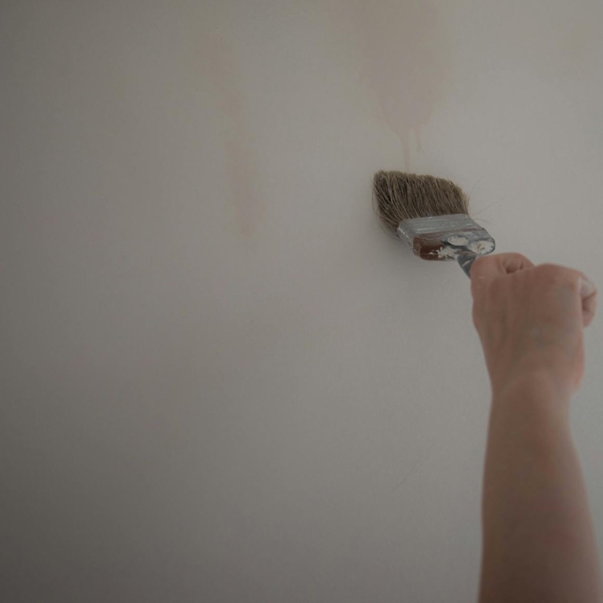 Iemand schildert thuis een muur als kleine klus