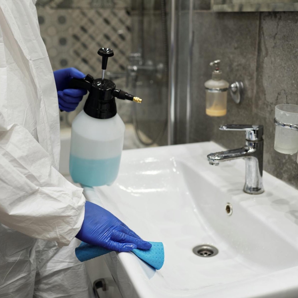 Schoonmaakster gebruikt spray bij huishoudelijke schoonmaak
