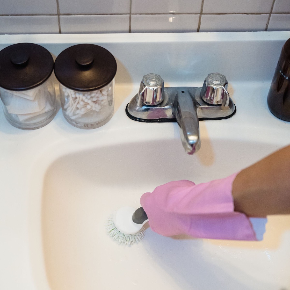 Schoonmaakhulp reinigt een wastafel